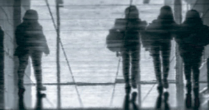 Four silhouetted figures walking across a reflective wet surface, their mirrored forms creating a moody, mysterious atmosphere that suggests tension, movement, and emotional depth